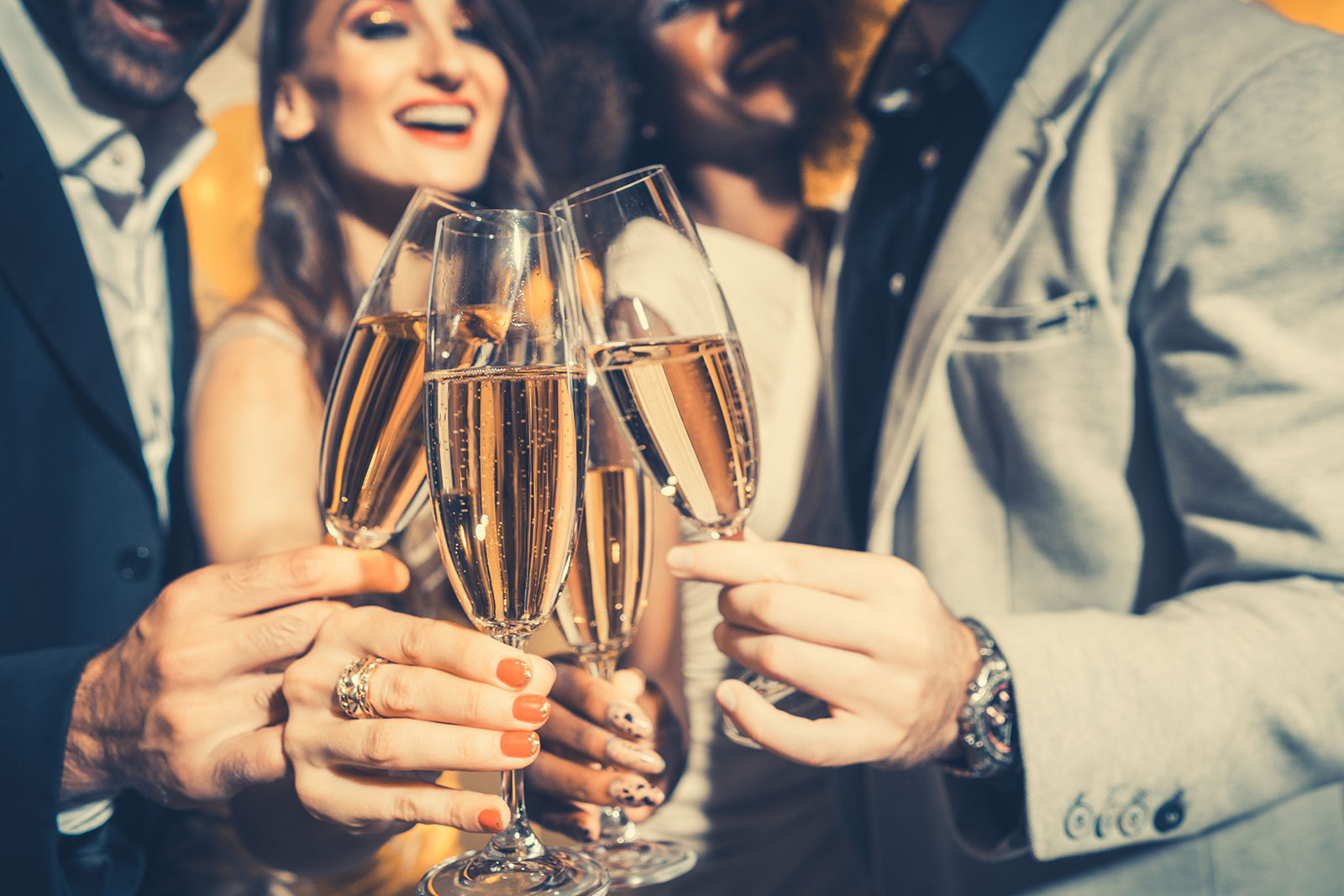 people celebrating holiday clinking glasses filled with champagne