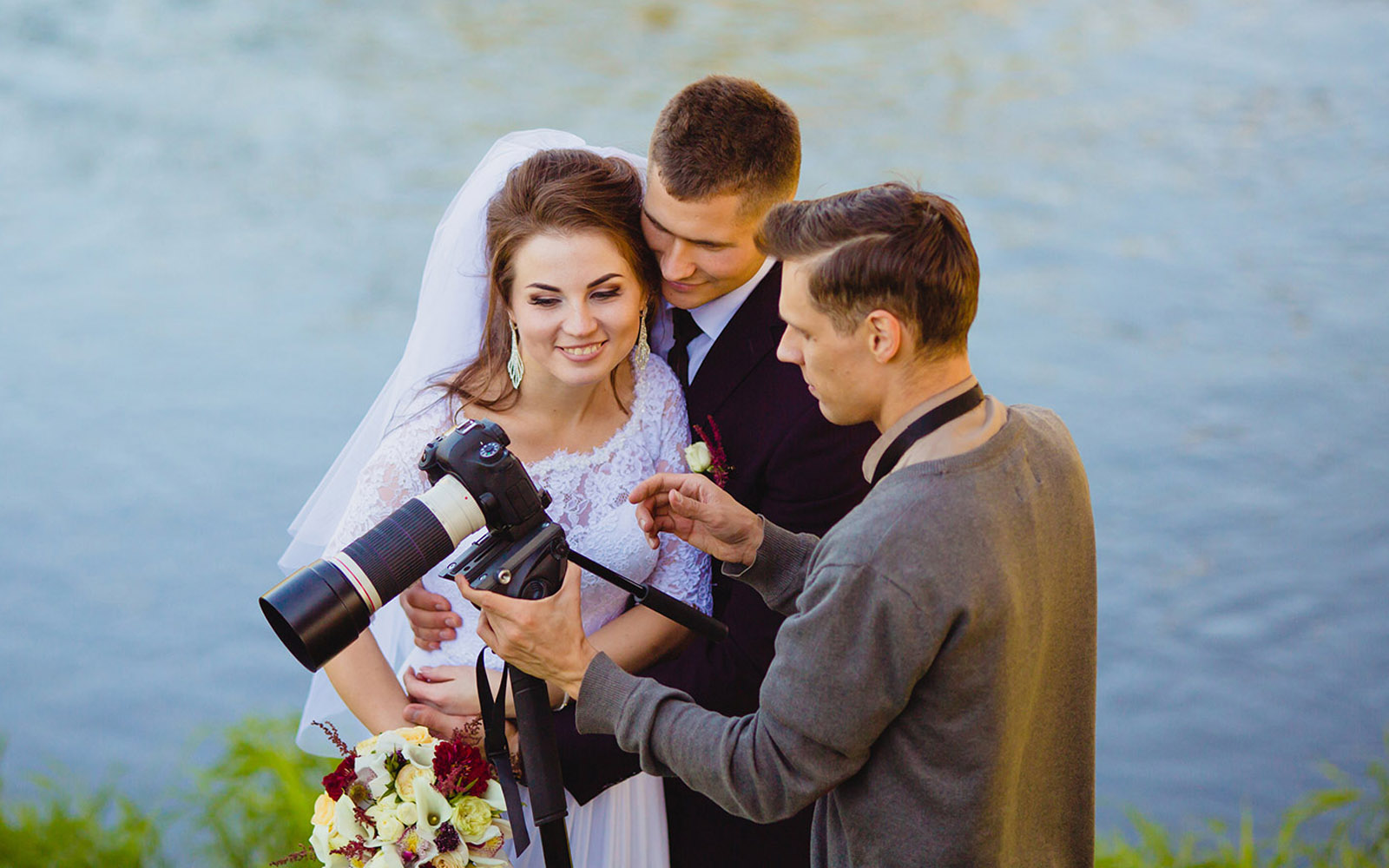 Wedding photographer reviewing photos with bride and groom